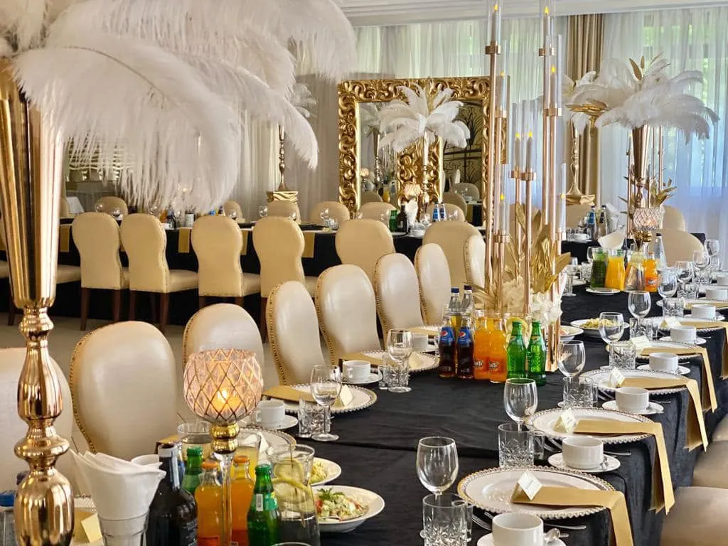 Odświętnie nakryte stoły ze złotymi dekoracjami w Restauracji K2